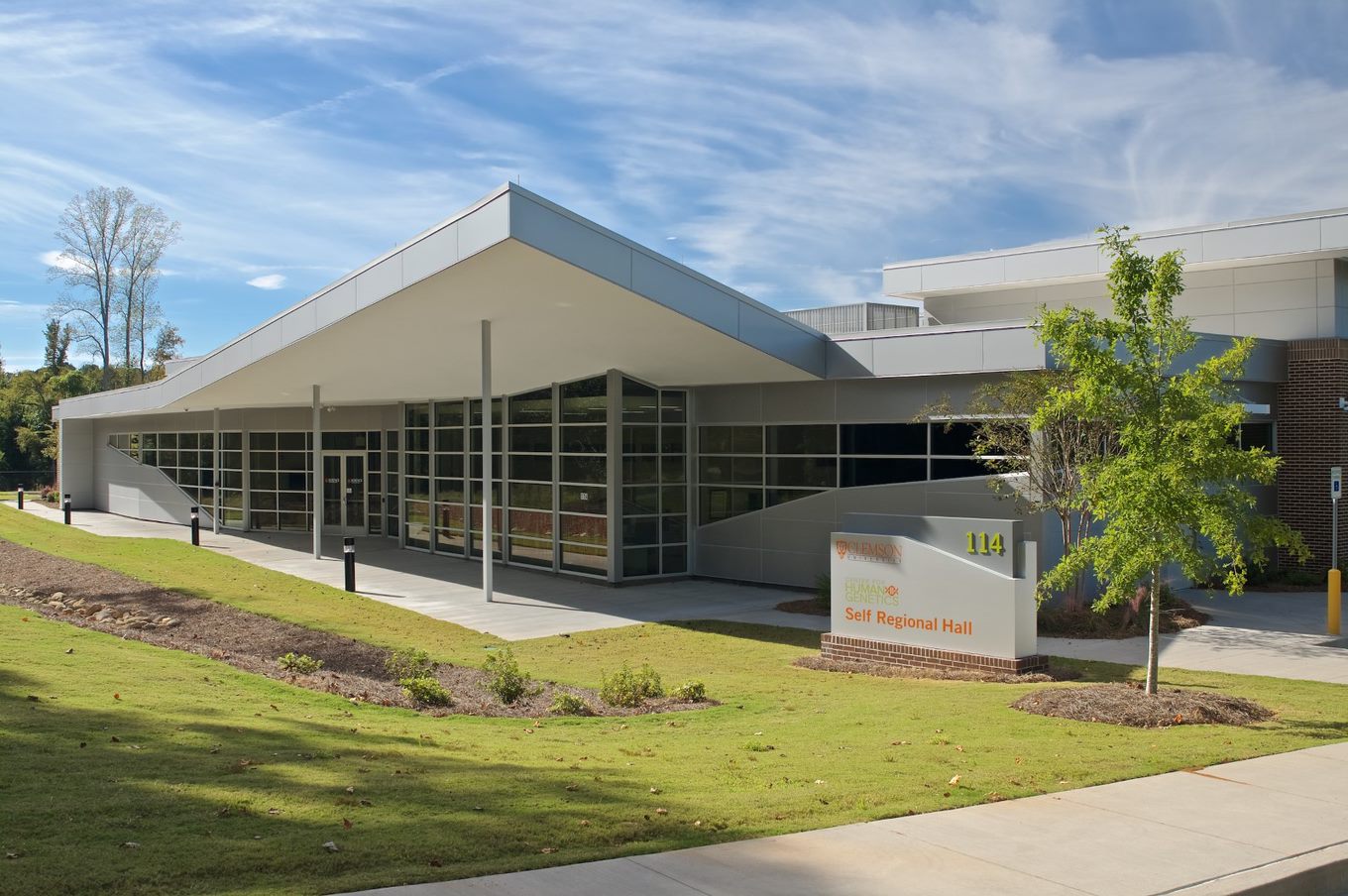 A one-story building with glass walls, a slanted roof, and a sign that says, "Self Regional Hall".